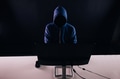 Anonymous and faceless hacker under hoodie using computer - PhotoDune Item for Sale