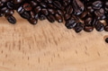 Heap of dark rustic coffee beans over wooden texture background. - PhotoDune Item for Sale