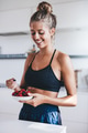 Happy female in kitchen eating fresh berries - PhotoDune Item for Sale