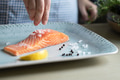 A person seasoning a fillet of salmon food photography recipe idea - PhotoDune Item for Sale