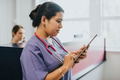 Female nurse checking the schedule on a tablet - PhotoDune Item for Sale