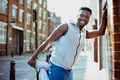 Athletic man stretching while leaning against a wall - PhotoDune Item for Sale