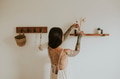 Woman placing aroma diffuser on wall shelf - PhotoDune Item for Sale
