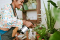 Small business worker misting plants with a water spray - PhotoDune Item for Sale