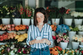 Woman using a phone in front of a flower shop - PhotoDune Item for Sale