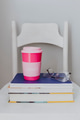 Pink travel mug on a stack of textbooks - PhotoDune Item for Sale