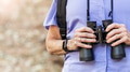 Senior woman with binoculars in the forest - PhotoDune Item for Sale