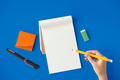Aerial view of hand holding pencil write notepad on blue table - PhotoDune Item for Sale