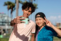 Cute teen couple take a selfie, summer in Venice Beach, Los Angeles - PhotoDune Item for Sale