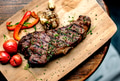 Grilled steak on wooden plate - PhotoDune Item for Sale