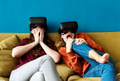 Two caucasian woman using VR on a sofa - PhotoDune Item for Sale