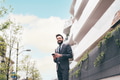 Young bearded elegant businessman outdoors using smartphone smiling - PhotoDune Item for Sale