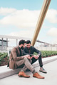 Two young businessman sitting outdoors sharing and using tablet - PhotoDune Item for Sale