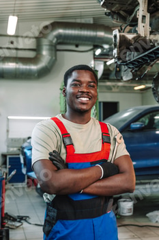 Portrait of young african man car service worker wearing uniform standing in garage