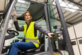 Female warehouse worker driving forklift. Warehouse worker preparing products for shipmennt - PhotoDune Item for Sale