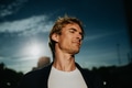 Portrait of handsome mature man with blond hair and closed eyes, standing outdoors in front of - PhotoDune Item for Sale