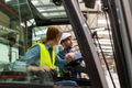 Forklift driver talking with manager in modern industrial factory. Warehouseman consulting order - PhotoDune Item for Sale