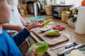 Boy helping mother to make school lunch in the kitchen. Preparing healthy snack for school. - PhotoDune Item for Sale