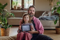 Father and girl holding smart thermostat, adjusting, lowering heating temperature at home. Concept - PhotoDune Item for Sale