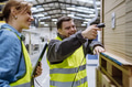 Young man with Down syndrome working in warehouse, female colleague teaching him scan products with - PhotoDune Item for Sale