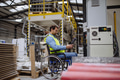 Portrait of man in wheelchair working in modern industrial factory, in adjustable workstation - PhotoDune Item for Sale