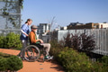 Nurse pushing senior man in wheelchair. Female caregiver and elderly man enjoying a warm autumn day - PhotoDune Item for Sale