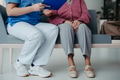 Close up of nurse and senior patient legs, sitting in hospital corridor and talking. Emotional - PhotoDune Item for Sale