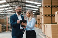 Female warehouse manager talking with logistics employee in warehouse, planning transport of - PhotoDune Item for Sale