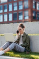 Young woman sitting in a city park and working on a laptop. - PhotoDune Item for Sale