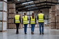 Rear view of warehouse workers walking in warehouse. Team of warehouse workers preparing products - PhotoDune Item for Sale