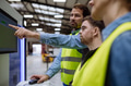 Young man with Down syndrome working in warehouse, colleague teaching him work with computer - PhotoDune Item for Sale