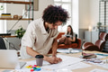 Young multiracial man drawing something in designers studio. - PhotoDune Item for Sale