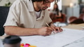 Young multiracial man drawing something in designers studio. - PhotoDune Item for Sale