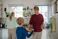 Family preparing breakfast together in home kitchen. Healthy breakfast or snack before kindergarden - PhotoDune Item for Sale