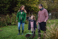 Young family taking care of home garden, planting tree. Mother, father and kids spending time - PhotoDune Item for Sale