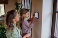 Girl helping mother to adjust, lower heating temperature on thermostat. Concept of sustainable - PhotoDune Item for Sale