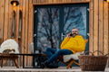 Mature man working from cozy cabin in mountains, sitting on terrace with laptop, enjoying cup of - PhotoDune Item for Sale