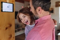 Father looking at smart thermostat, adjusting, lowering heating temperature at home. Concept of - PhotoDune Item for Sale