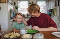 Father and son eating breakfast together in home kitchen. Healthy breakfast or snack before - PhotoDune Item for Sale