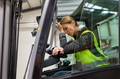 Female warehouse worker driving forklift. Warehouse worker preparing products for shipmennt - PhotoDune Item for Sale