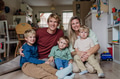 Portrait of family at home sitting on the floor. Beautiful mother with her three sons and husband in - PhotoDune Item for Sale