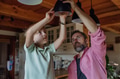 Father explaining led bubls to son, teaching him about energy efficiency, longevitiy and - PhotoDune Item for Sale