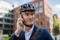 Handsome man commuting through the city by bike, making call with smartphone. Male city commuter - PhotoDune Item for Sale