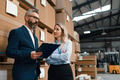Female warehouse manager talking with logistics employee in warehouse, planning transport of - PhotoDune Item for Sale