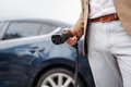 Close up of a businessman charging electric car. - PhotoDune Item for Sale