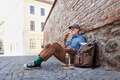 Elderly man with backpack sitting by brick wall, eating healthy homemade snack, resting. Traveling - PhotoDune Item for Sale