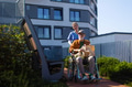 Nurse pushing senior man in wheelchair. Female caregiver and elderly man enjoying a warm autumn day - PhotoDune Item for Sale