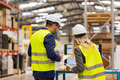 Female engineer and male supervisor standing in modern industrial factory, talking about production - PhotoDune Item for Sale