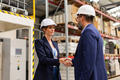 Female engineer and male project manager shaking hands in modern industrial factory. Manufacturing - PhotoDune Item for Sale