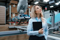 Female manager standing in modern industrial factory. Manufacturing facility with robotics and - PhotoDune Item for Sale
